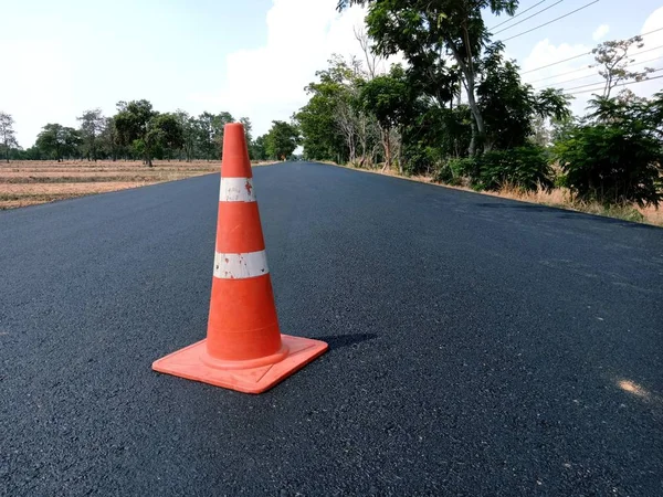 La carretera está en construcción y tiene un cono de goma roja en el — Foto de Stock