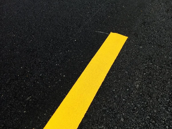 Het wegverkeer verf geel op het asfalt oppervlak — Stockfoto