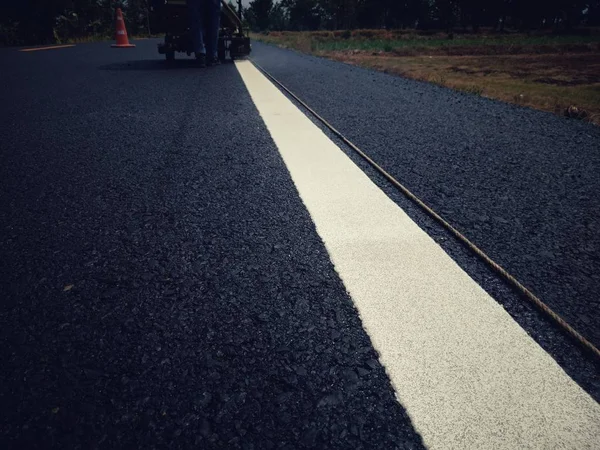 Vägtrafiken måla vitt på asfalt ytan — Stockfoto