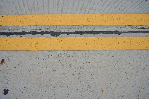 Gelbe Verkehrsfarbe auf Betonstraße — Stockfoto