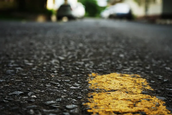 La carretera pavimentada tiene líneas de tráfico amarillas en la superficie. Borrosa. — Foto de Stock