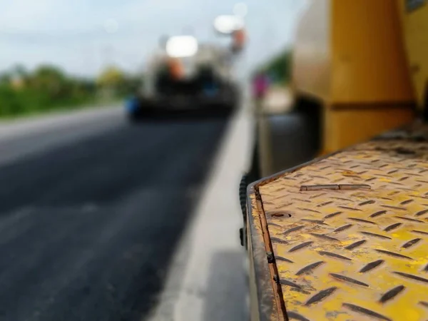 Road maintenance by the ASPHALT HOT MIX IN - PLACE RECYCLING (blurred image).
