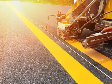 İşçiler sarı çift katı çizgiyi geçiyor. Makine kullanarak.