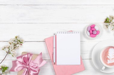 Çalışma masasının yaratıcı düzlüğü, istek listesi için not defteri ve ahşap arka plandaki yaşam tarzı nesneleri