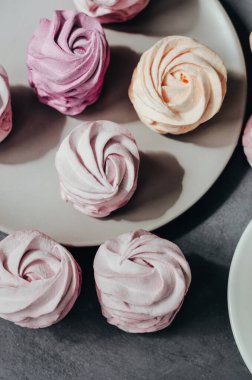 Gri arka planda renkli hava marşmelovları. Taze ev yapımı tatlı zephyr.