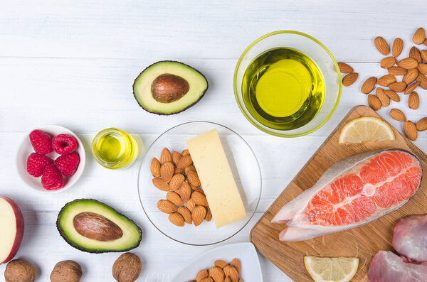 Keto diet, low carb healthy food. avocado, fish, oil, nuts on white background