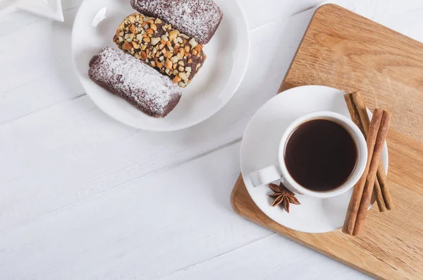 Чорна чашка кави з анісом, корицею та шоколадними цукерками на дерев'яному фоні. вид зверху — стокове фото