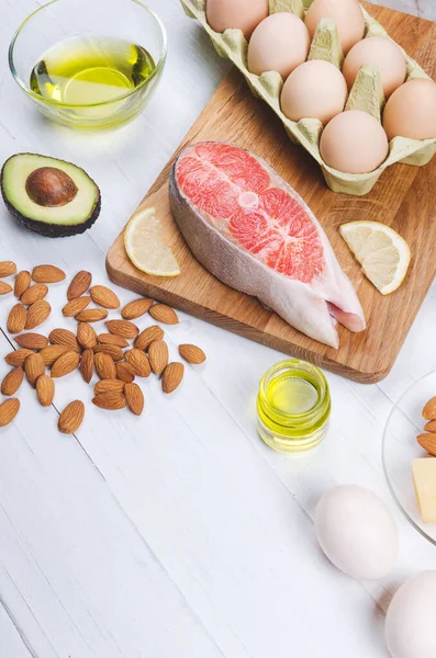 Keto diyeti, düşük karbonhidratlı sağlıklı yiyecekler. avokado, balık, yağ, beyaz arka planda fındık.