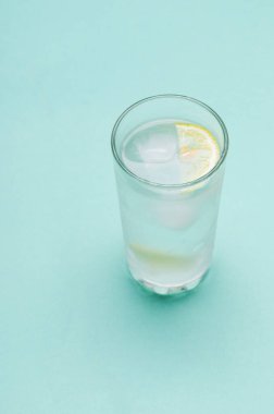 Mavi arka planda buzlu ve limonlu kokteyl.