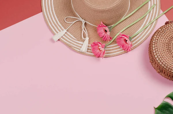 Летняя соломенная шляпа, цветок и соломенный мешок на розовом фоне. — стоковое фото