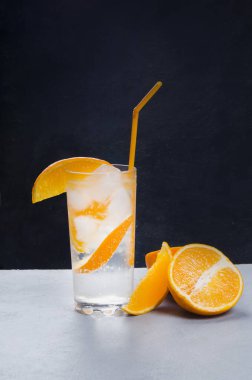 Gri ve siyah arka planda portakal meyveli portakal alkollü kokteyl.