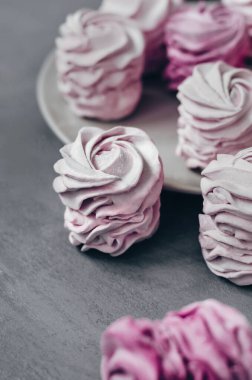 Gri arka planda renkli hava marşmelovları. Taze ev yapımı tatlı zephyr.