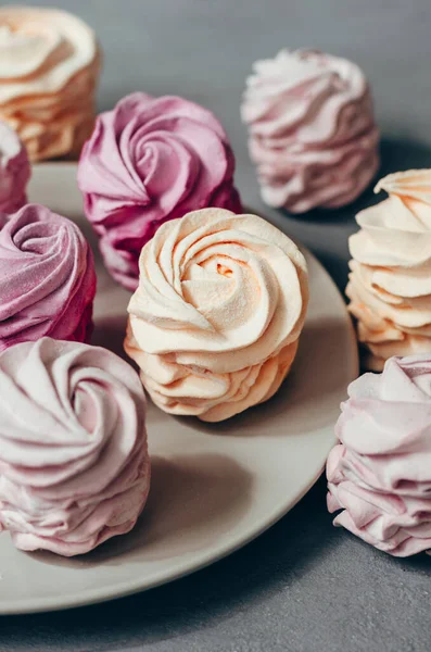 Gri arka planda renkli hava marşmelovları. Tatlı zephyr.