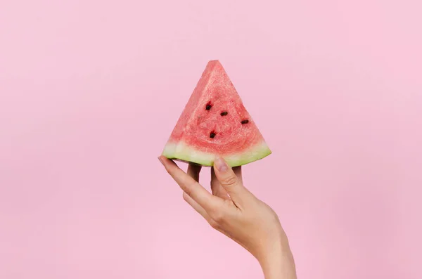 Hand holding slice of watermelon on pink background — Stock Photo, Image