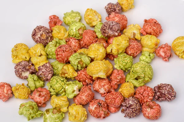 A pile of colorful caramel popcorn, still life for a holiday with colorful popcorn on white wooden table