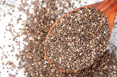 Masanın üzerindeki tahta kaşıkta sağlıklı Chia tohumları.