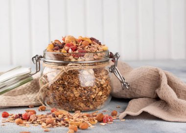 Sağlıklı kahvaltı - yulaf gevreği, kurutulmuş meyve, çilek ve açık renkli fındık granola cam kavanoz .