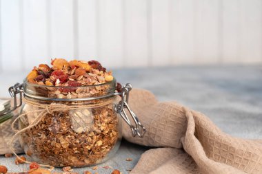 Sağlıklı kahvaltı - yulaf gevreği, kurutulmuş meyve, çilek ve açık renkli fındık granola cam kavanoz .