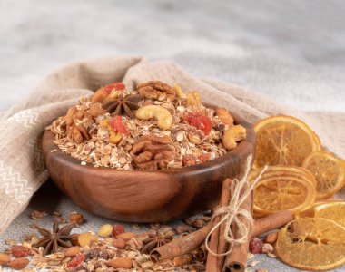 Ahşap kase fındık, granola ile kurutulmuş cranberries ve turuncu masa lambası eski üzerinde kurutulmuş.