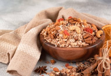 Ahşap kase fındık, granola ile kurutulmuş cranberries ve turuncu masa lambası eski üzerinde kurutulmuş.