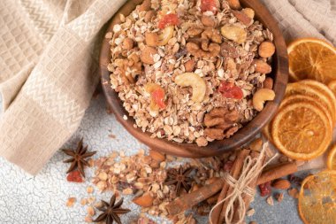 Ahşap kase fındık, granola ile kurutulmuş cranberries ve turuncu masa lambası eski üzerinde kurutulmuş.