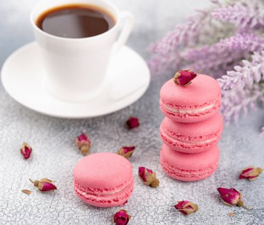 Pembe macaroons kurutulmuş çiçek tomurcukları ve kahve. Pastel renkli