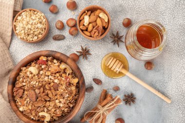 Ahşap kase maddeler - yulaf, fındık, bal ve baharat tarçın ve anason ile ev yapımı granola.