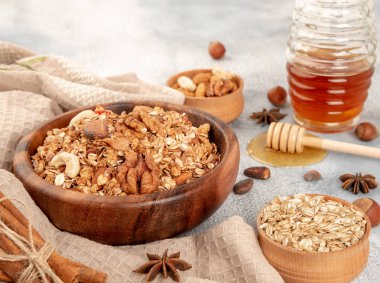 Ahşap kase maddeler - yulaf, fındık, bal ve baharat tarçın ve anason ile ev yapımı granola.