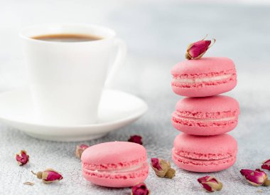 Pembe macaroons kurutulmuş çiçek tomurcukları ve kahve. Pastel renkli
