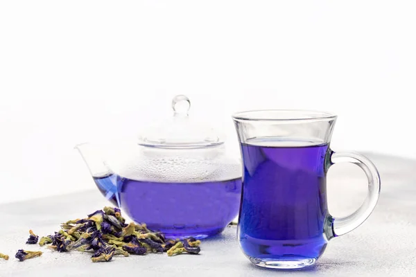 Organic blue tea Anchan, Clitoria, Butterfly Pea in glass cup and glass teapot.