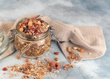 Sağlıklı kahvaltı - yulaf gevreği, kurutulmuş meyve, çilek ve açık renkli fındık granola cam kavanoz .