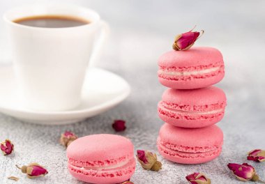 Pembe macaroons vintage bir tabak ve kurutulmuş çiçek tomurcukları. Pastel renkli.