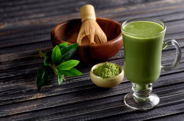 Koyu ahşap arka plan cam bardakta Matcha yeşil çay kahve içecek.