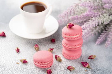 Pembe macaroons kurutulmuş çiçek tomurcukları ve kahve. Pastel renkli