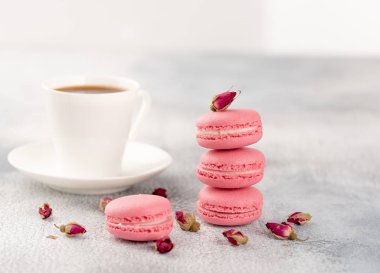 Pembe macaroons kurutulmuş çiçek tomurcukları ve kahve. Pastel renkli