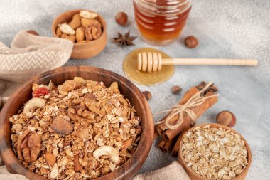 Ahşap kase maddeler - yulaf, fındık, bal ve baharat tarçın ve anason ile ev yapımı granola.