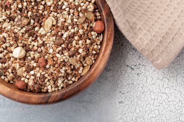 Sağlıklı Kahvaltı, fındık ve ahşap kase kabak çekirdeği ile yeşil buğday vegan vejetaryen granola yapılmış
