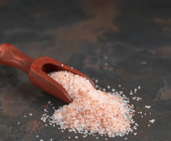Розовая гималайская соль в деревянной чаше на черном фоне — стоковое фото