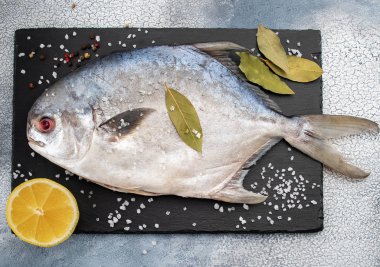 Masada taze çiğ balık pompano ve baharat malzemeleri