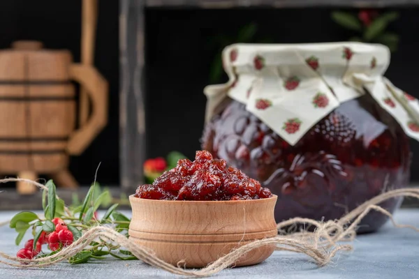 Mermelada de Lingonberry o salsa en un tazón de madera y en un frasco de vidrio — Foto de Stock