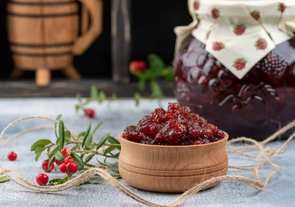 Mermelada de Lingonberry o salsa en un tazón de madera y en un frasco de vidrio con cr — Foto de Stock