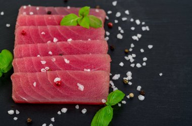 Fesleğenli taze ton balığı bifteği. Siyah kırsal arka planda. Boşluğu kopyala