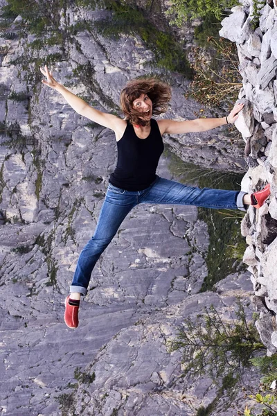Genç kız. Gri kaya. Dağlarda bekletin. Acrobat.