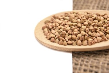 Nötr arka plan. Buğday taneleri. Sağlıklı gıda. Tahta kaşık.