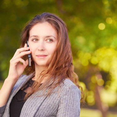 Cep telefonu açık havada kullanan genç kız. Danışman gibi bahseden gençlik kadın. Sohbet iş.