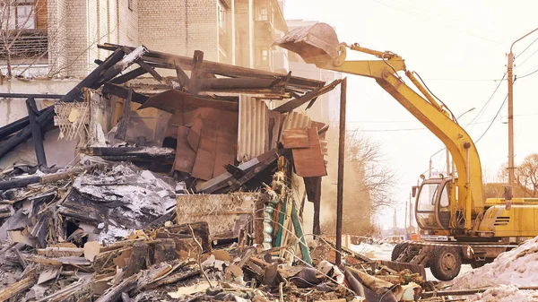 Demolition house using excavator in city. Rebuilding process. Remove equipment.