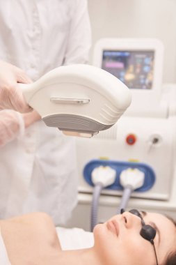 Sağlık Güzellik Lazer cosmeology yordam. Salonunda genç kadın. Profesyonel doktor. Kadın Cilt Bakımı teknolojisi. Epilasyon.