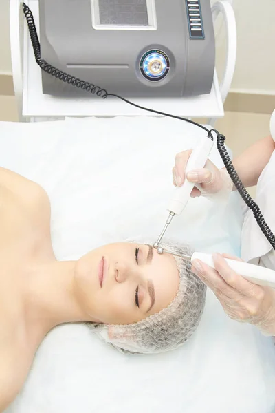 Facial micro current cosmetology procedure. Beauty technology treatment. Woman face therapy.