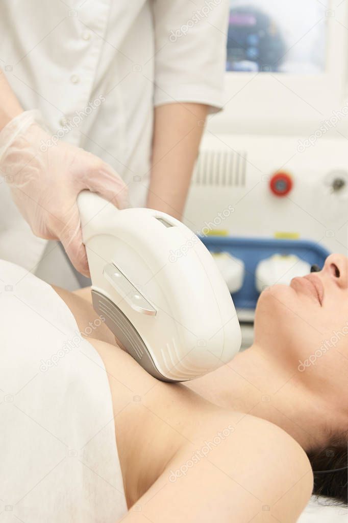 Medical beauty laser cosmeology procedure. Young female at salon. Professional doctor. Woman skincare technology. Hair removal.
