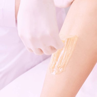 Depilasyon spa yordamı. Kadın saç kaldırmak ağda. Sugaring epilasyon. Bacaklar ayak.